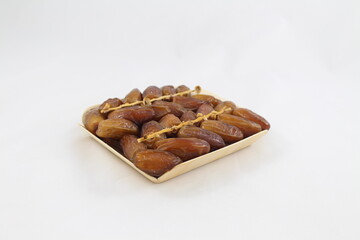 Cardboard tray of date fruits on grey background