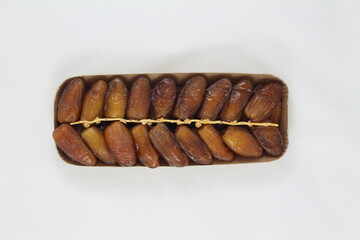Cardboard tray of date fruits on grey background