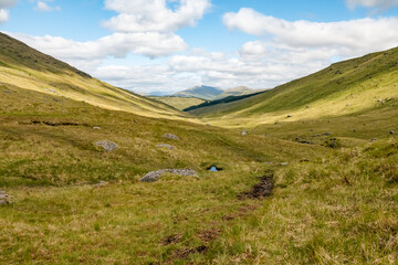 Beautiful mountainous landscape of the Trossachs National Park in Scotland in the summer with hills, valleys, river streams, reservoirs and mountain peaks