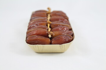Cardboard tray of date fruits on grey background