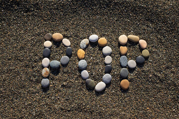 Word pop made from stones on sandy beach.