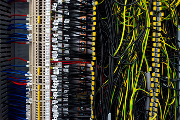 Electrical wiring harnesses connected to terminals in the control cabinet of an industrial machine....