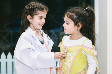Little girls playing in kindergarten. Performance of two kids, doctor with her patient