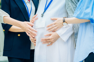 妊娠中の女性と話す、さまざまな年代の女性
