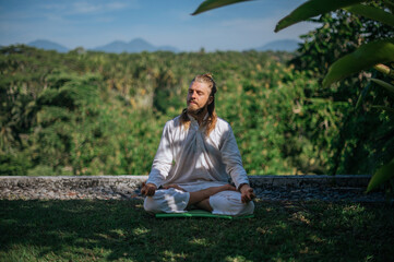 Yoga practice and meditation in nature. Man practicing near river