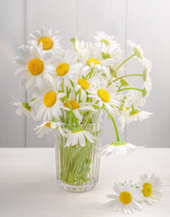 Bouquet of white daisies in a glass.