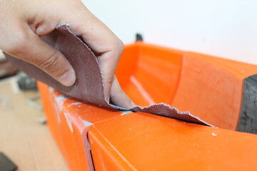 A person's hand sanding a 3d printed piece of artwork