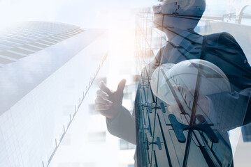 Engineer with construction helmet standing in front of skyscraper buildings in the city, close up