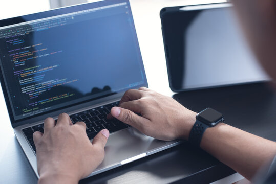 Developing programmer, software developer coding computer code on laptop computer. Digital software development. Website and mobile app design and coding technologies.