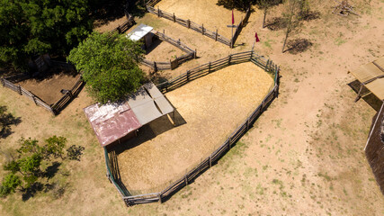 Aerial view on a horse riding exercise fence. The riding school is the place where horses are...