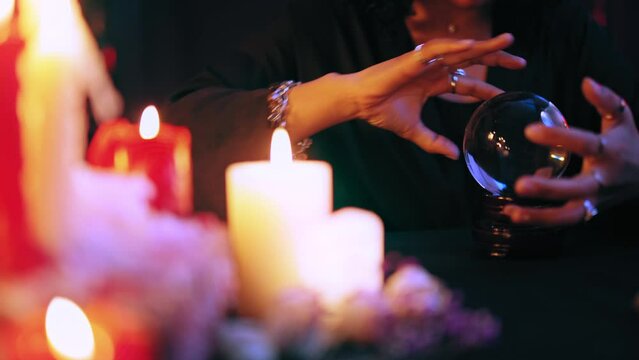 Experienced witch performing ritual over crystal ball, channeling spirits, magic