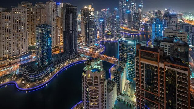 Panorama showing various skyscrapers in tallest recidential block in Dubai Marina and JDR district aerial night timelapse with artificial canal. Many towers and yachts