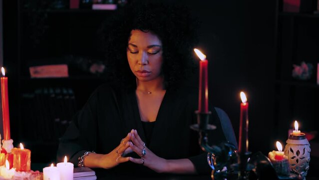 Skilled witch saying spells with closed eyes, mysterious ritual, voodoo magic