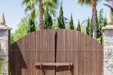 Wooden gates in the medieval style closed with bolts. Fairy gate in the southern amusement park...