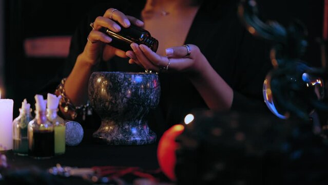 Witch cooking magic potion, adding components, mortar alchemy and spells