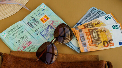 money and sunglasses, pounds dollars and euro banknotes peeking out of leather bag with kazakhstan...