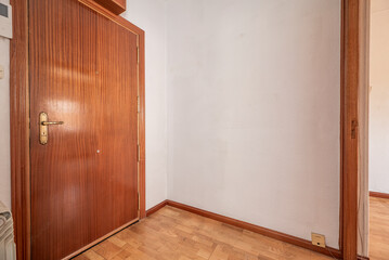 Entrance hall of a house with parquet floors, mahogany woodwork and off-white painted walls