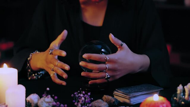 Woman performing magic ritual over crystal ball, forecasting future, witch
