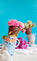 Cucuruchos de chocolate rellenos de flores. Fondo azul