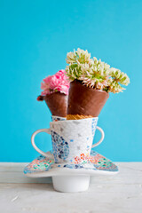 Cucuruchos de chocolate rellenos de flores. Fondo azul