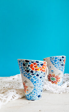 Tazas con forma c&oacute;nica y teselas decoradas. Fondo azul