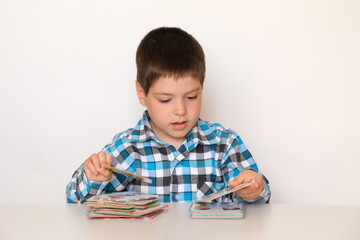 A boy of 4 years old plays with cards with pictures, educational materials for preschool children.
