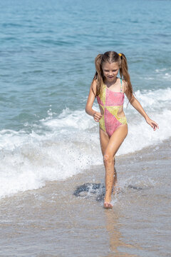 A happy little girl runs along Cleopatra Beach in Alanya, Turkey.