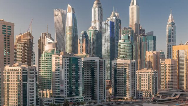 Dubai marina tallest block of skyscrapers timelapse. Aerial view from JLT district to apartment buildings, hotels and office towers. Traffic on a highway