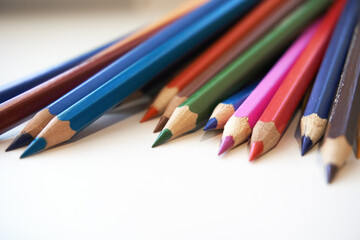 Colored pencils for drawing and coloring, on a white background. Figures made of colored pencils, stationery, school supplies