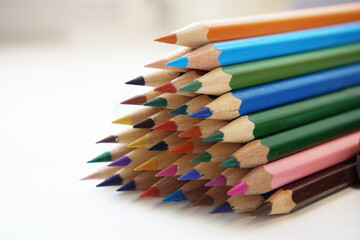 Obraz premium Colored pencils for drawing and coloring, on a white background. Figures made of colored pencils, stationery, school supplies