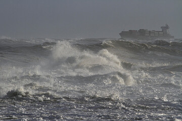Fototapeta na wymiar Stormy sea with a ship on the horizon