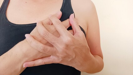 Elderly woman holding her chest.