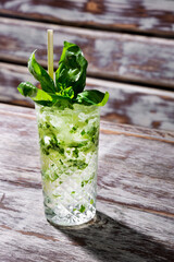 Cocktail with basil, ice and a straw