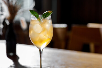 A cocktail with ice, syrup and basil
