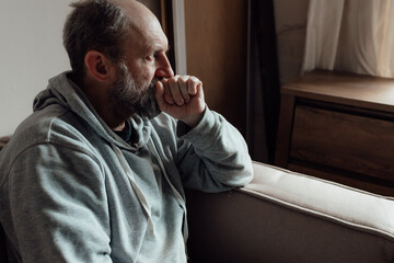 Ukrainian worried middle aged man was frightened by the loud sound and closed his ears in fear....