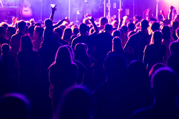 Fototapeta na wymiar Concert Crowd Silhouettes in Purple Lights