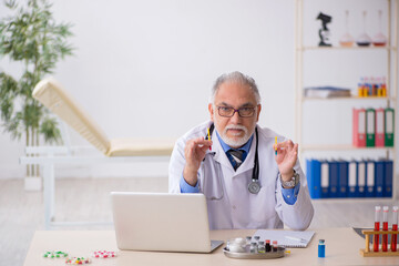 Old male doctor pharmacist working at the lab - obrazy, fototapety, plakaty