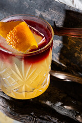 Cocktail with ice, orange peel and syrup