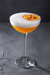 A cocktail with ice, orange, peppercorns and foam