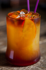 Cocktail with ice, fruit and a straw