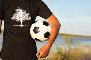 Man holding a soccer ball on the Riverside field