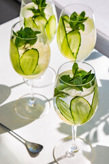 Three cocktails with ice, cucumbers and mint