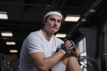 Handsome young sportsman looking focused, warming up for his gym workout