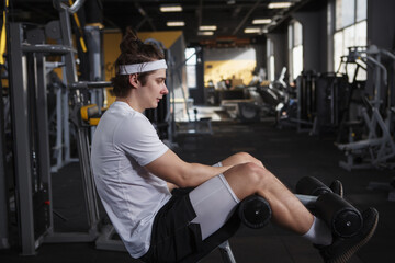 Profile shot of a male athlete doing abs exercise at the gym, copy space