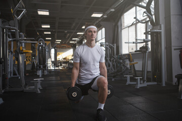 Fototapeta na wymiar Full length shot of a sportsman doing weighted lunges with dumbbells