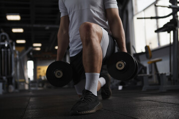 Fototapeta na wymiar Cropped shot of a sportsman doing weighted lunges at gym