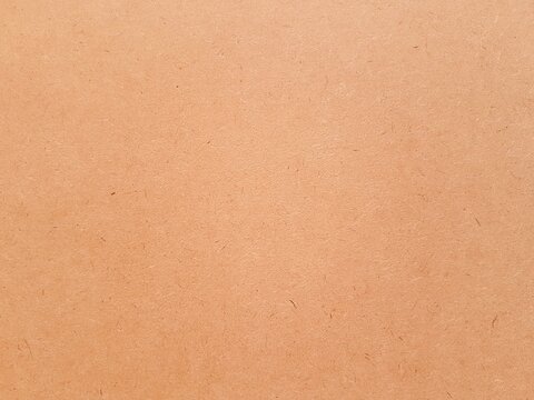 Orange color paper texture and grain for aesthetic of autumn and fall design. Color and light on warm earth tone paper background.