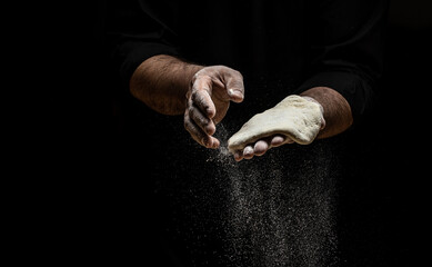 Beautiful and strong men's hands knead the dough from which they will then make bread, pasta or...