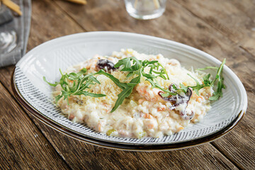Portion of gourmet seafood risotto on wooden background
