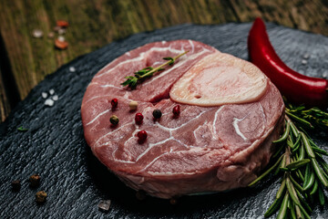 Raw Ossobuko steak marble meat with herbs and spices on dark background. banner, menu, recipe place...